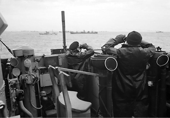 Oficiales británicos vigilan el paso de un convoy desde el puente de un destructor. Octubre de 1941.